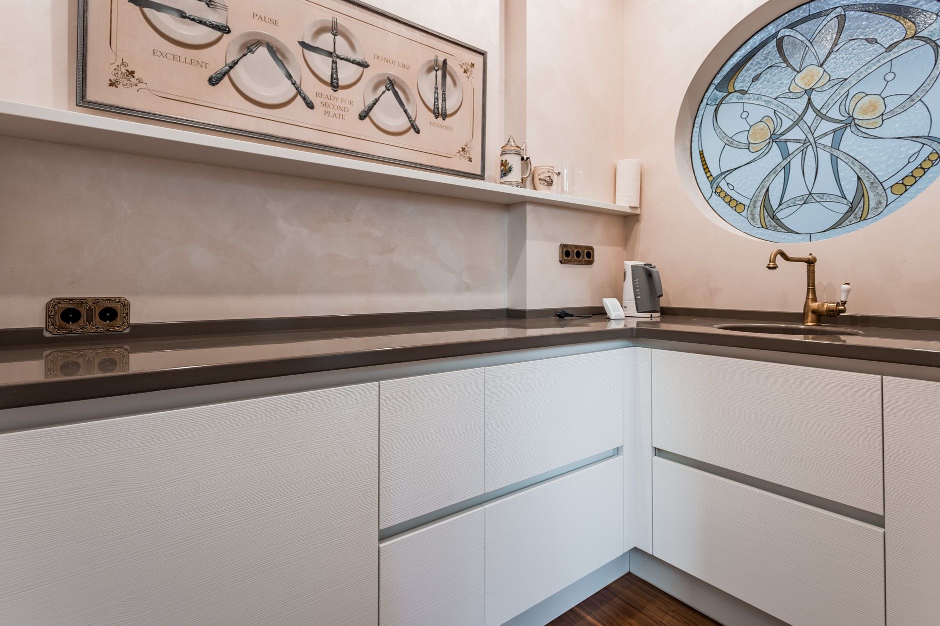Corner kitchen with a sink, white cabinets and a window